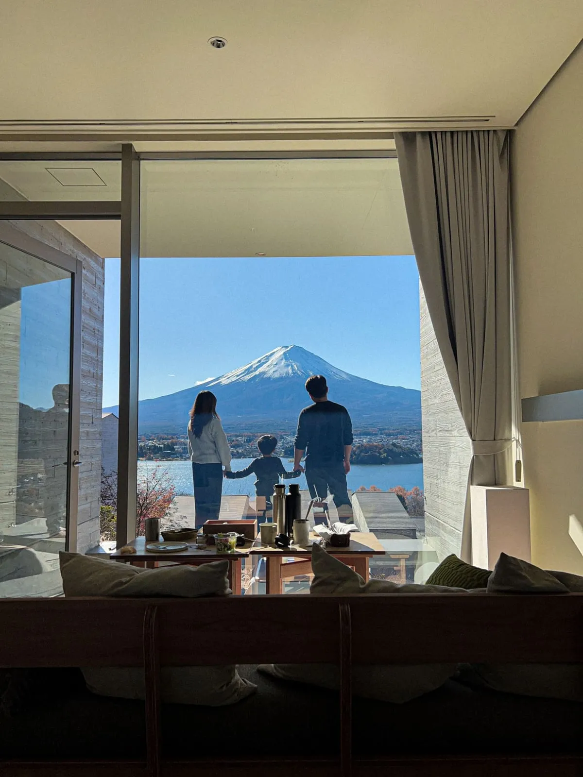 A family of three looking out at Mount Fuji from a window