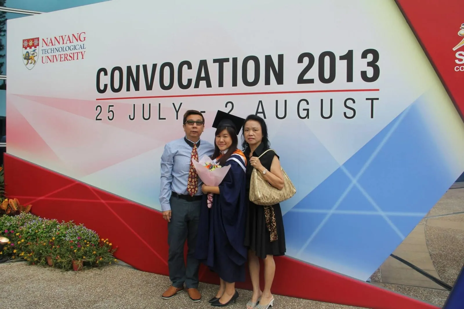 Shermene in her graduation gown at the 2013 convocation, holding flowers